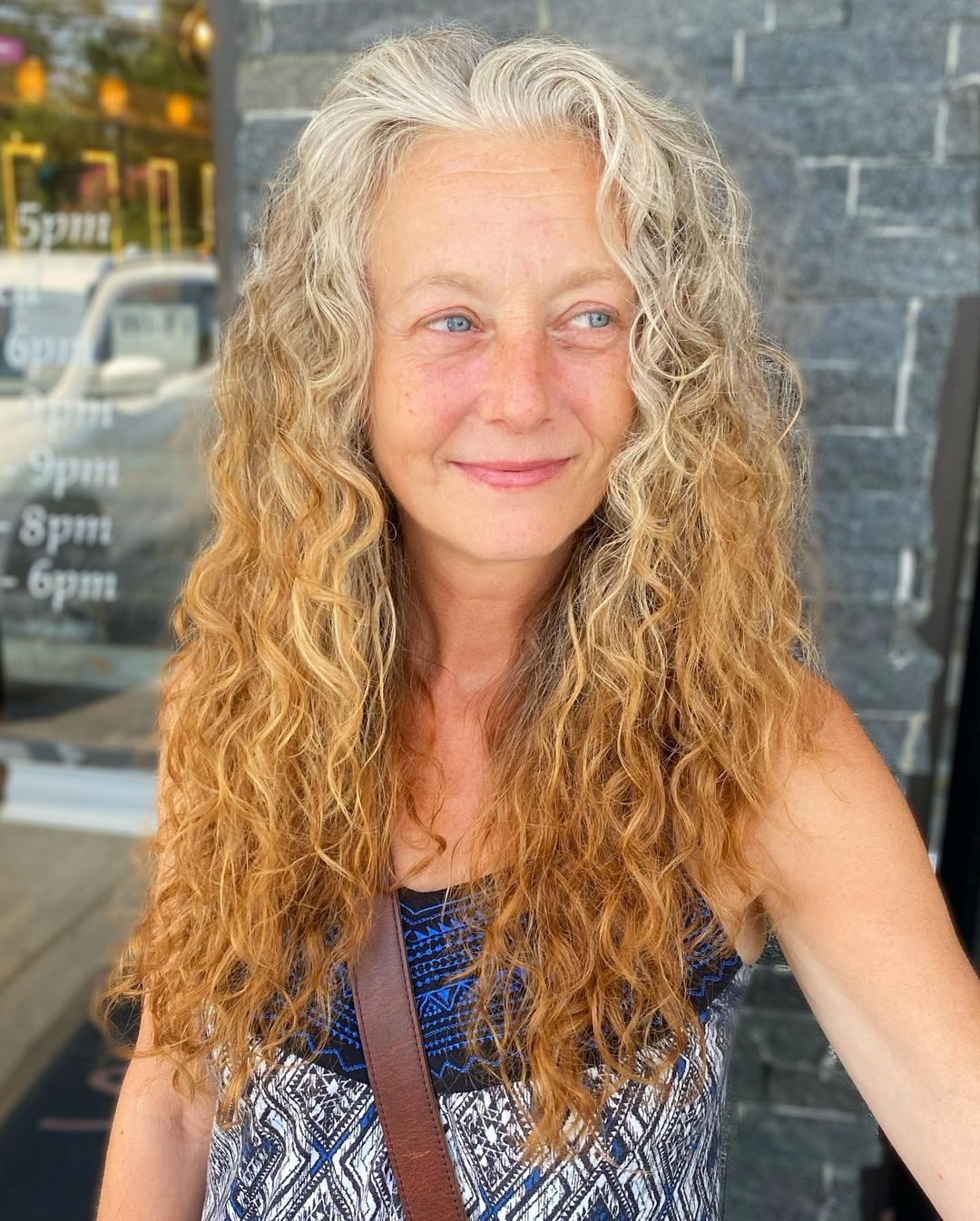 Woman over 60 with Long Curly Hair Growing Our Gray